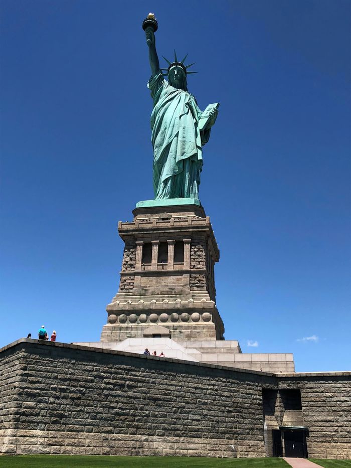 Iconic Statue of Liberty under clear blue sky in New York, a symbol of freedom and democracy.