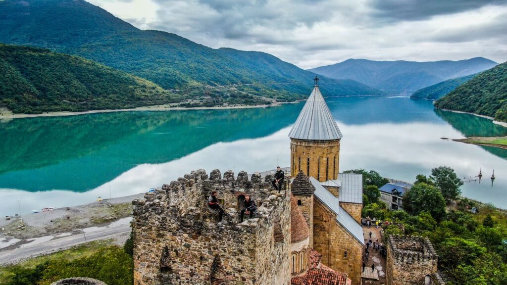 Stunning aerial view of Ananuri Fortress by a serene lake in the mountains of Georgia.